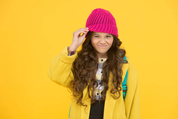 Hat really bothers me. Small kid dislike wearing hat. Little kid take off hat on yellow background. Cute kid in formal autumn style. Small kid with beauty look go to school - Foto, Imagem
