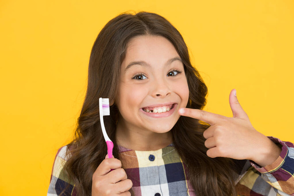 She had her baby tooth out. Happy child show milk tooth removed. Small girl with open mouth and tooth brush. Tooth fairy will visit her - Zdjęcie, obraz