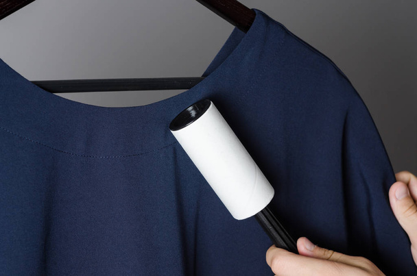 pulizia dell'abito con rullo adesivo adesivo adesivo
 - Foto, immagini
