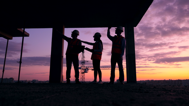 Ingenieurteam arbeitet auf dem Sonnenuntergang-Baugrundstück - Filmmaterial, Video