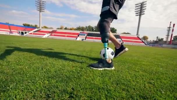 Footballer with a bionic leg is running with a ball - 映像、動画