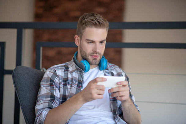 Bearded man playing video game on smartphone - Foto, Imagem