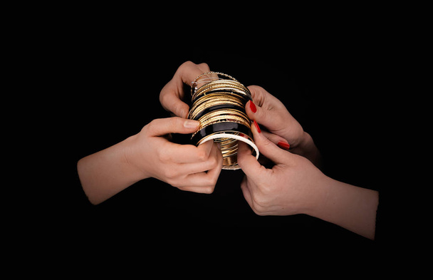 Two caucasian womans hands with golden bracelets - Photo, image