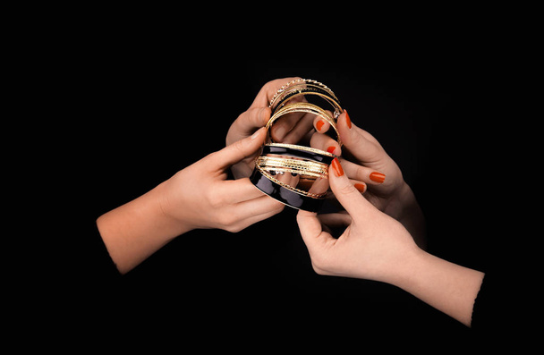 Two caucasian womans hands with golden bracelets - Foto, afbeelding