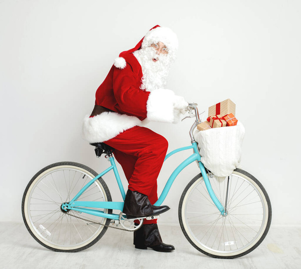 Санта Клаус катается на ретро-велосипеде, полном рождественских подарков
 - Фото, изображение