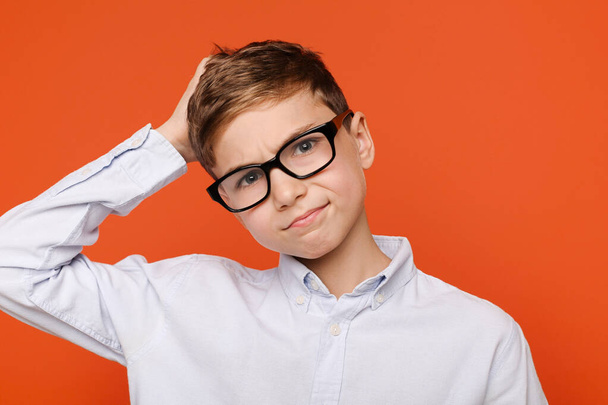 Pochybný dospívající chlapec v brýlích škrábání na hlavě, - Fotografie, Obrázek