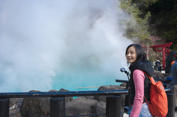 Asian tourist woman takes a photo at Hot spring (Hell) onsen, hot blue water The "sea hell" in Umi Jigoku at Beppu, Oita-shi, Kyushu, Japan - Photo, Image