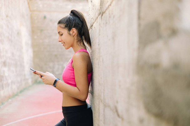 Cropped photo of fit woman with her phone - Foto, Imagem