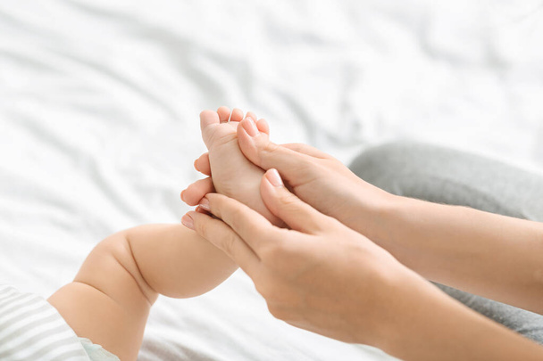 Mère massant les petits pieds des bébés, ce qui rend le renforcement gymnastique
 - Photo, image
