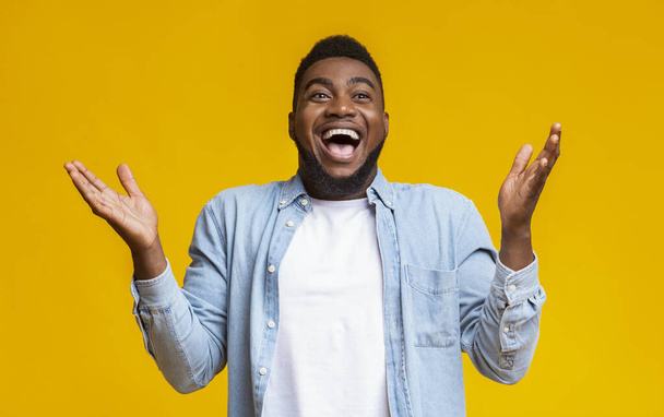 Retrato de homem americano africano alegre levantando as mãos em espanto
 - Foto, Imagem