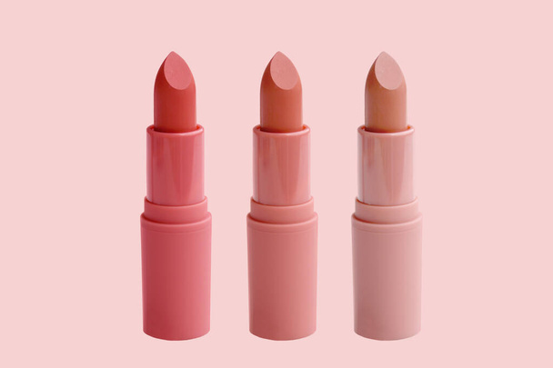 set of matte lipstick on a delicate pink background, red, raspberry, pink, coral, peach color, close-up, the concept of decorative cosmetics - Photo, image