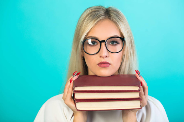 beautiful young woman in glasses holds books on a blue background - Photo, Image