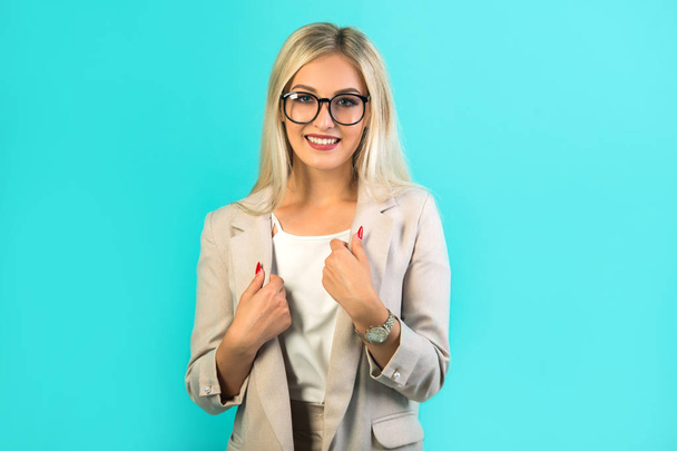 beautiful young woman in suit with glasses on a blue background - Photo, Image