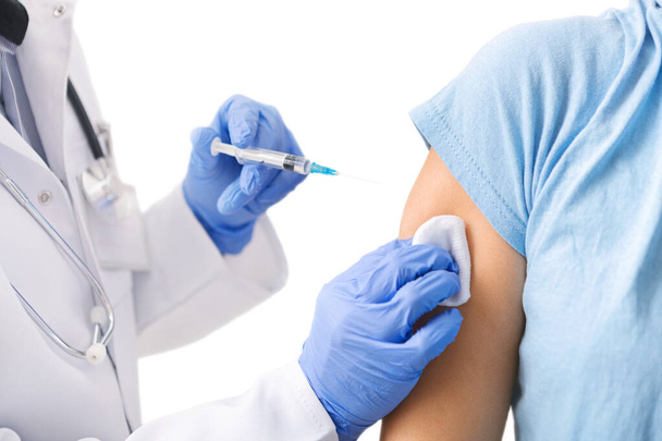 Γιατρός που κάνει την ένεση εμβολιασμού, φορώντας μπλε γάντια και ιατρικό φόρεμα - Φωτογραφία, εικόνα