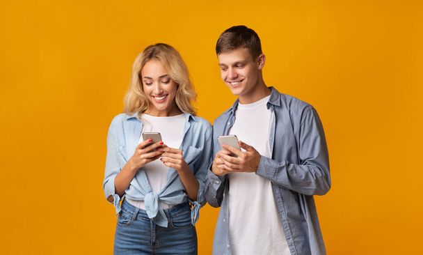Curious boyfriend peeking into girlfriends smartphone, trying to read messages - Foto, Bild