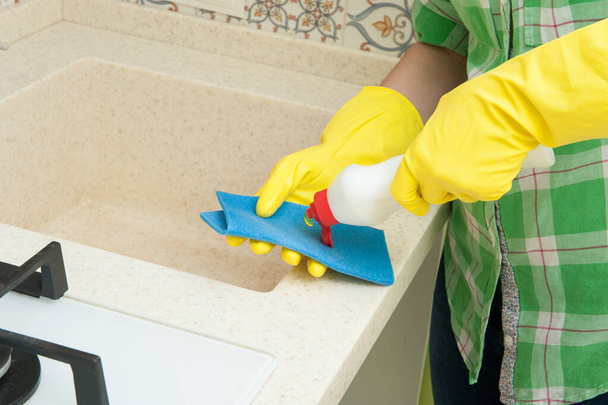 Meisje Handschoen wast kasten, fornuis en wastafel in de keuken - Foto, afbeelding