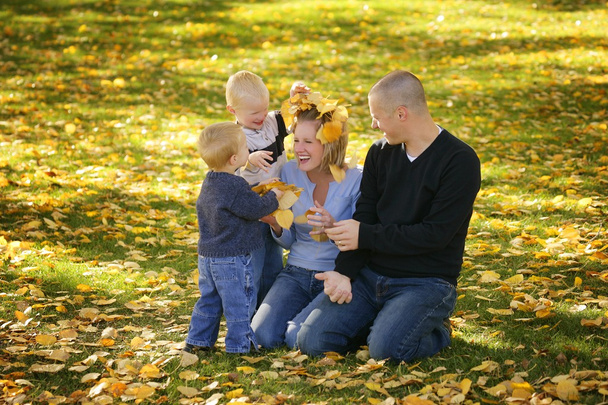 Los niños espolvorean hojas en mamá
 - Foto, Imagen
