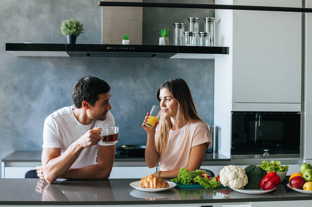 Photo of young couple starting the day together with coffee in the kitchen - Foto, Bild