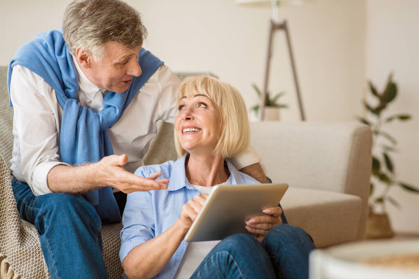Współcześni starsi małżonkowie korzystający razem z tabletu cyfrowego - Zdjęcie, obraz
