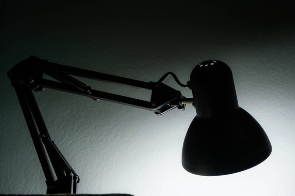 Silhouette di una lampada da tavolo sullo sfondo di una finestra al mattino all'alba, lavoro fino al mattino, lavoro di notte
. - Foto, immagini