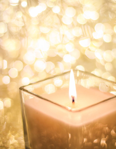 Aromatische kaars op gouden kerst en nieuwjaar glitter backgr - Foto, afbeelding