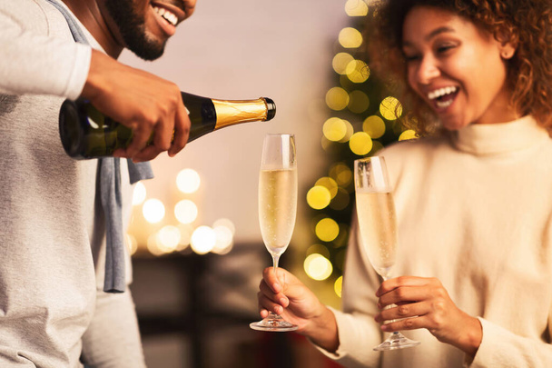 Hombre vertiendo champán en las copas, celebrando la Navidad
 - Foto, imagen
