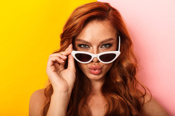 Photo of glamorous alluring woman making kiss lips and holding eyeglasses while looking at camera - Фото, зображення