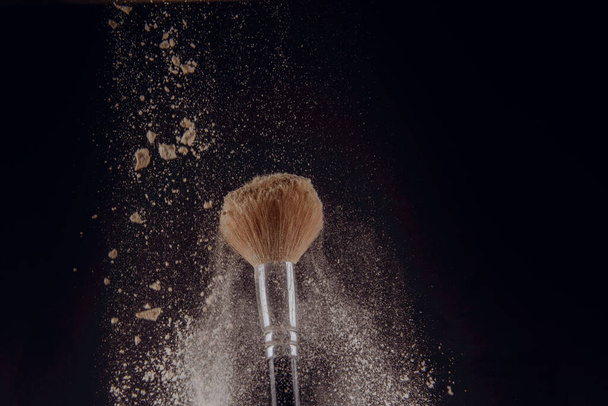 isoliertes Make-up Puder mit Pinsel auf schwarzem Hintergrund - Foto, Bild