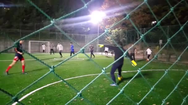 Chuncheon, Güney Kore - Ekim, 25-2019: gece futbol maçı izleniyor. Oyuncular yeşil çimlerin üzerinde spot ışıkları altında futbol oynuyorlar. - Video, Çekim