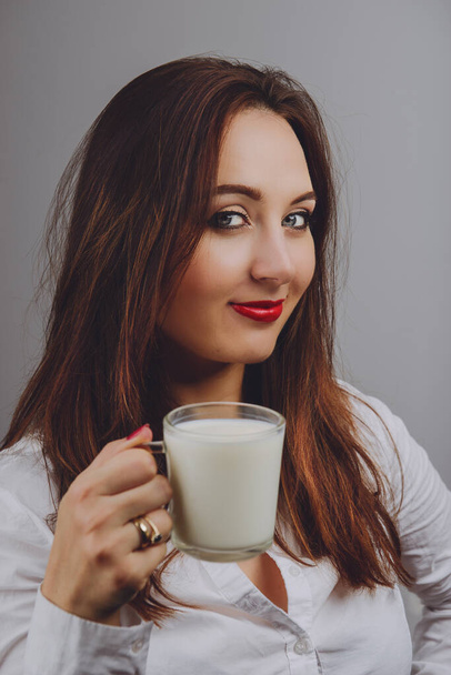 Vidám lány gazdaság tej bögre a kezében - Fotó, kép