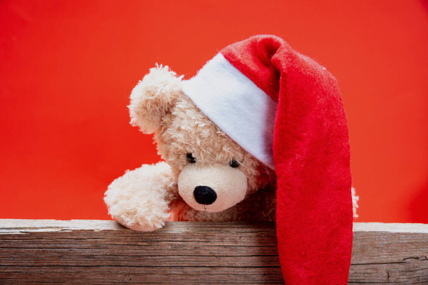 Ведмедик Тедді з капелюхом Санти, червоний колір фону
 - Фото, зображення