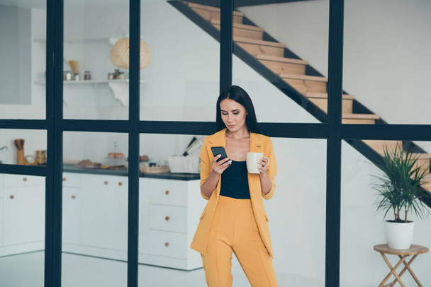 Portrait of her she nice attractive charming lovely pretty smart trendy lady drinking aromatic coffee typing sms message in modern style light white glass interior apartment house - Φωτογραφία, εικόνα