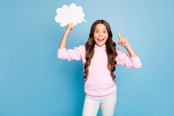 Photo of pretty little lady wavy hairdo hold empty paper cloud raising finger have creative idea for dialogue answer wear casual sports wear pink hood isolated blue color background - Photo, Image