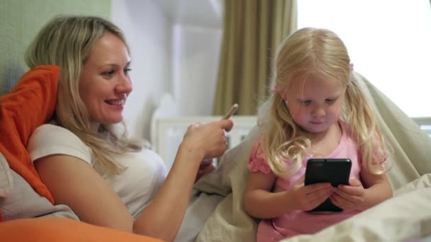 Mutter und Kind mit Smartphone zu Hause. - Filmmaterial, Video