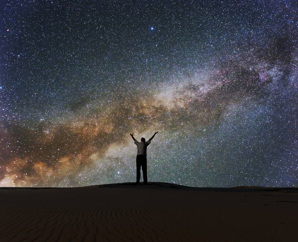 man with hangs up under a starry sky with milky way, night prayer - Photo, Image