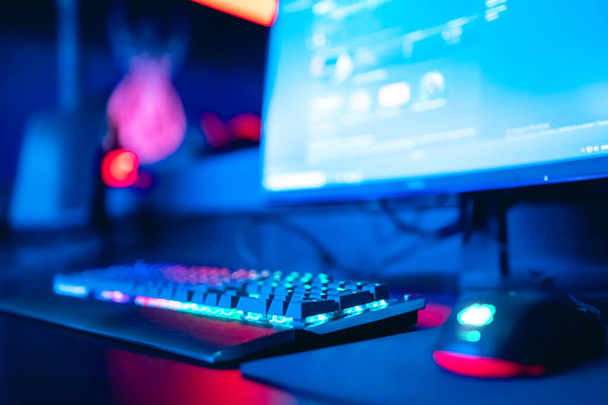verschwommener Hintergrund Computer, Tastatur, blaues und rotes Licht. Konzept sieht Arena für Spieler vor, die Turniere spielen - Foto, Bild