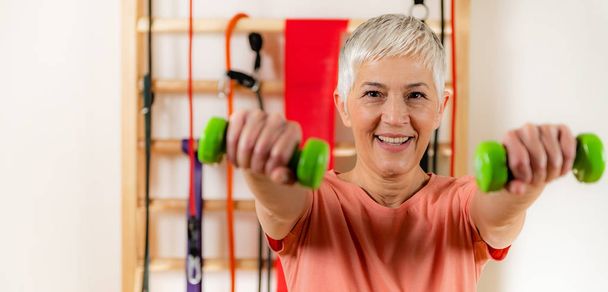 Retrato de una mujer mayor haciendo ejercicio con pesas - Foto, Imagen
