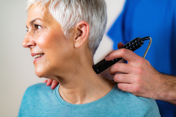 Laser Physical Therapy. Physical Therapist Treating Senior Woman's Neck in a Clinic - Photo, image