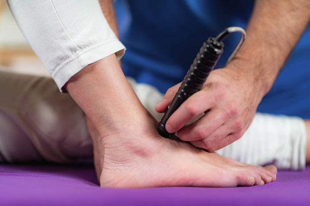 レーザー理学療法。理学療法士クリニックでシニア女性の足を治療 - 写真・画像