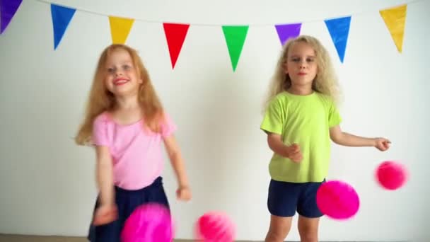 Girls pretending cheerleaders holding pink pompon paper balls. camera motion - 映像、動画