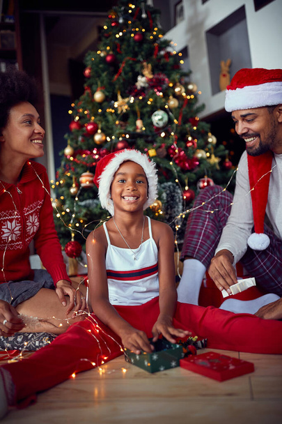 Happy family in front of decorated Christmas tree have fun - Photo, image