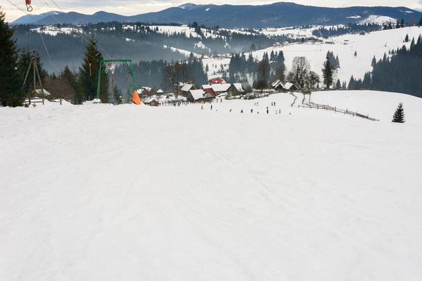Лыжники зимой отдыхают в украинском селе Карпаты
. - Фото, изображение