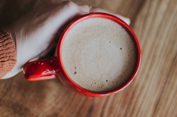 taza roja con café mokachino en un café sobre un fondo oscuro
 - Foto, imagen