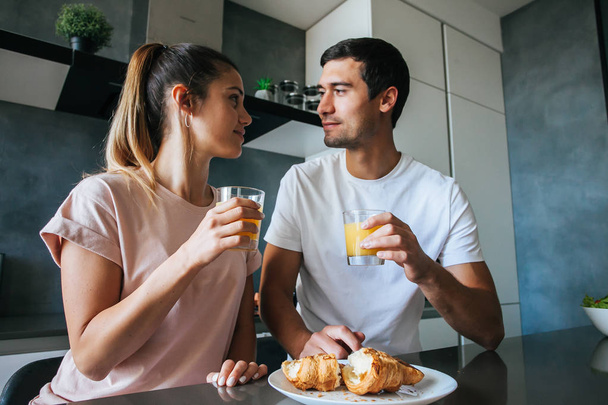 Photo of young couple starting the day together with coffee in the kitchen - Zdjęcie, obraz
