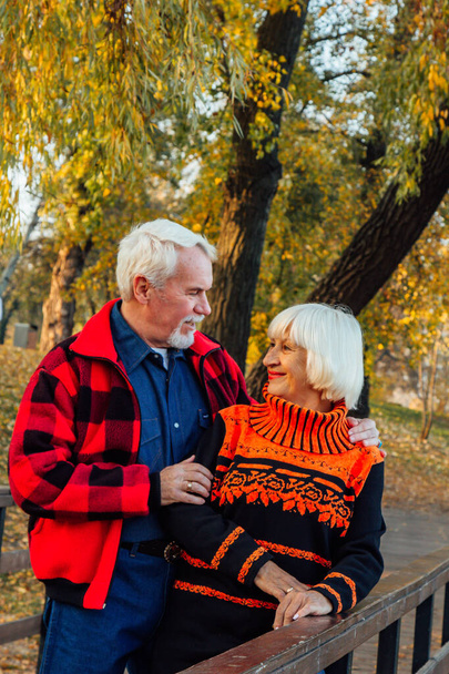 Glückliches Seniorenpaar, das sich im Park amüsiert. Unterstützung und Fürsorge von einem geliebten Menschen, warme Emotionen. - Foto, Bild
