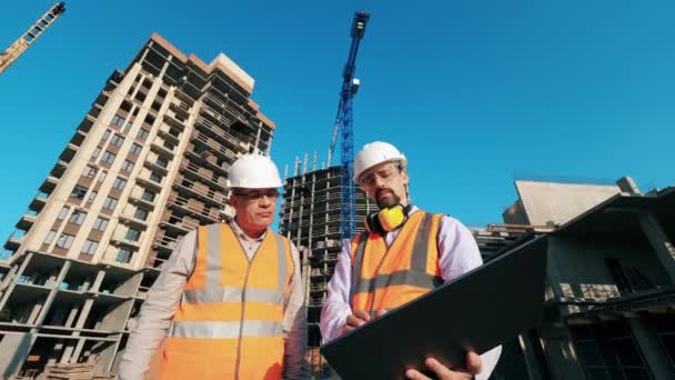 Building lot with two architects operating a computer - Footage, Video