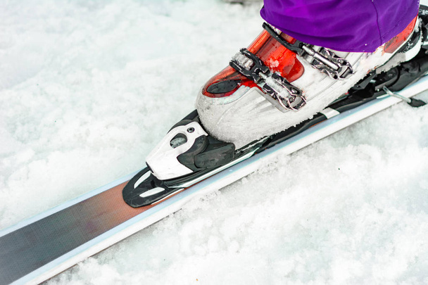 O esquiador atleta demonstra um conjunto de esquis e botas na perna
. - Foto, Imagem