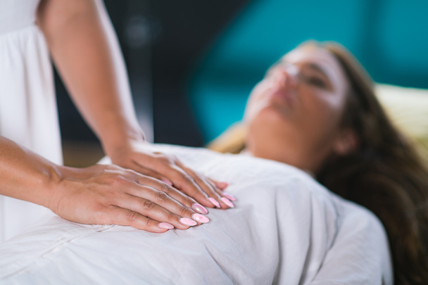 Female Therapist Performing Reiki Therapy Treatment. Hands Over Woman's Stomach. Alternative Therapy Concept, Stress Reduction and Relaxation.   - Photo, Image