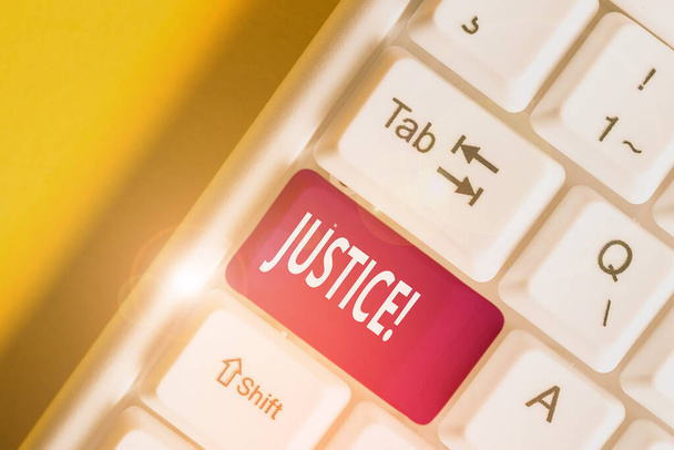 Conceptual hand writing showing Justice. Business photo showcasing impartial adjustment of conflicting claims or assignments White pc keyboard with note paper above the white background. - Photo, Image