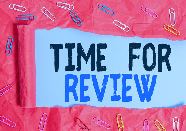 Text rukopisu Time For Review. Pojetí znamená přezkum systému nebo situace při jeho formálním zkoumání Klip na papír a roztržená lepenka umístěná nad prostým pastelovým stolem. - Fotografie, Obrázek